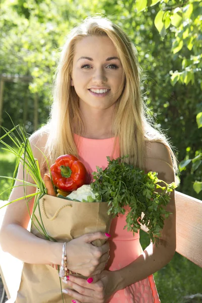 Ung kvinna med en shoppingväska. grönsaker — Stockfoto