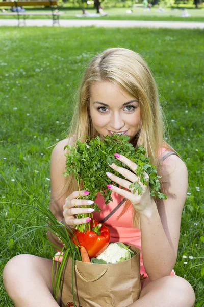 Ung kvinna med en shoppingväska. grönsaker — Stockfoto
