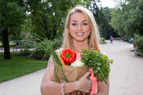 带着购物袋的年轻女人。蔬菜 — 图库照片