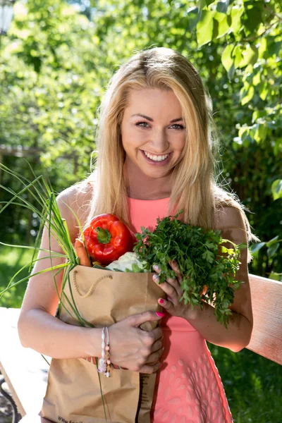 Junge Frau mit einer Einkaufstasche. Gemüse Stockbild