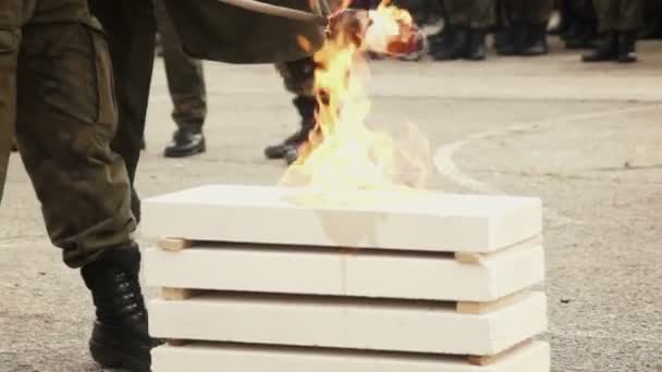 Ung soldat förstöra brinnande tegelstenar — Stockvideo