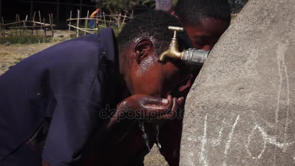 Αφρικανική ο νεαρός πίνει νερό απευθείας από τη βρύση — Αρχείο Βίντεο