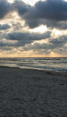 Kumlu sahilde altokümülüs bulutları