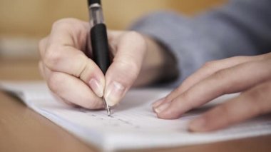 Not defterine mesaj yazan genç bir kızın detaylı görüntüsü.