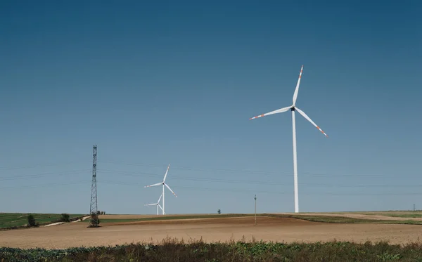 Порожні поля і вітрові турбіни над ясним блакитним небом — стокове фото