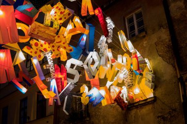 1 June 2019, Lublin, Poland: art installation created from colorful letters hanging over street at the old town of Lublin during Night of Culture Festival