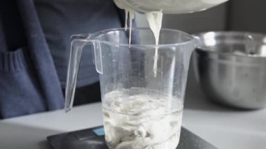 Ev yapımı ekmeği plastik bir ölçü içinde suya dönüştürmek için hamur yerleştirmek 