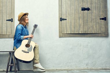 Gitar ile gülümseyen kız portresi.