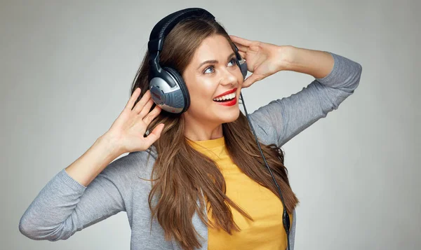 Glücklich tanzende Frau mit Kopfhörern auf grauem Hintergrund — Stockfoto