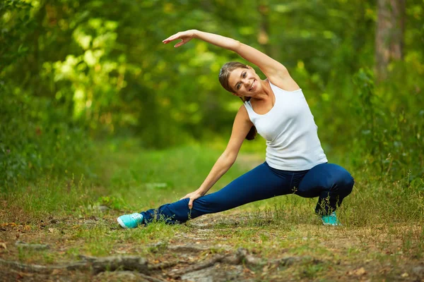 Lächelnde Frau bei Stretchübungen — Stockfoto