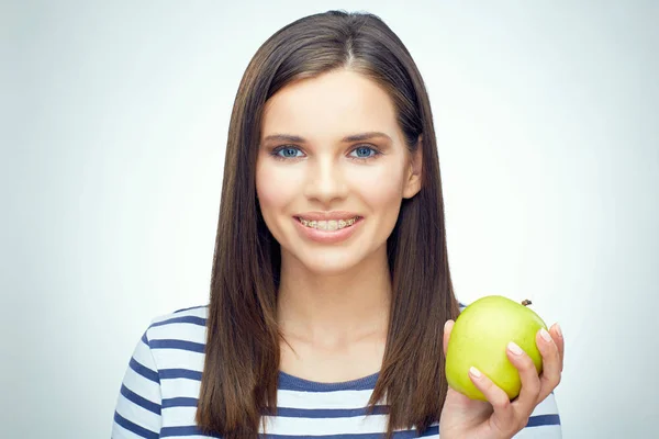 Счастливая девушка с зубными скобками держа зеленое яблоко . — стоковое фото