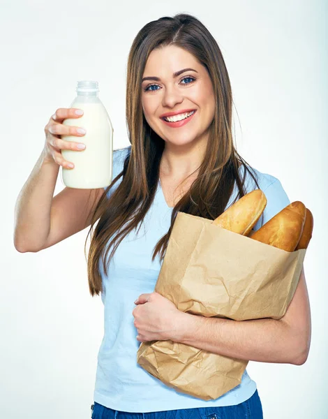 Sonriente mujer feliz sosteniendo bolsa de papel con pan y muestra la leche —  Fotos de Stock