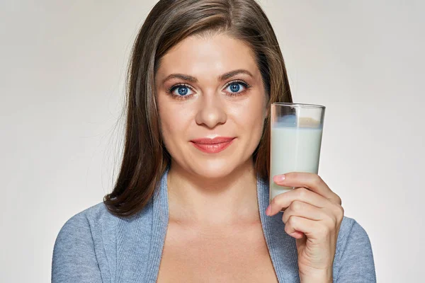 Retrato de cerca de la cara de una mujer joven sosteniendo un vaso de leche . —  Fotos de Stock