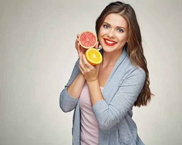 Mujer sonriente sosteniendo media naranja y pomelo . — Foto de Stock