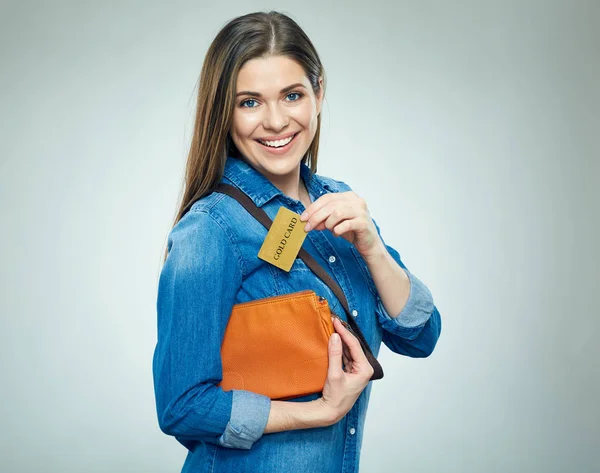 Usmívající se dívka vytáhne zlatou kreditní kartu od kabelky. — Stock fotografie