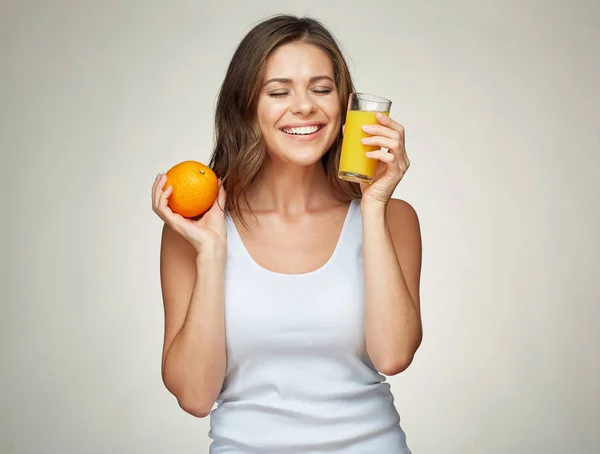 Mujer feliz con los ojos cerrados sostiene fruta naranja y jugo . — Foto de Stock