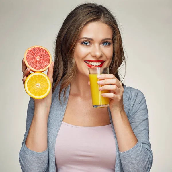 Mulher sorrindo segurando copo de suco com meia laranja e toranja — Fotografia de Stock