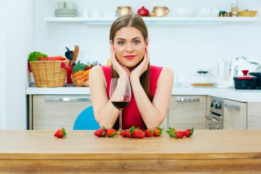 Gülümseyen kadın portre Şarap kadehi ile mutfakta.