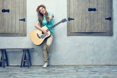 Gitar ile sokakta duran genç gülümseyen kadın 