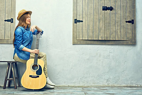 Womann sitting on bench with guitar. — Stock Photo, Image