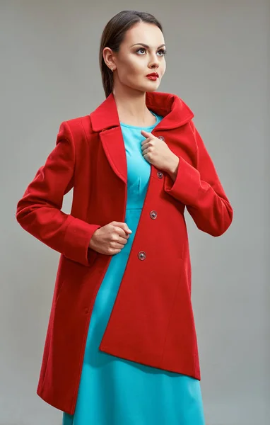 Modelka oblečený v červeném kabátě a světle modré šaty pózuje i — Stock fotografie