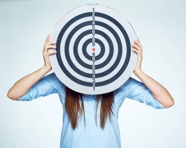 Kadın yüzünü yuvarlak hedef arkasında gizler. 