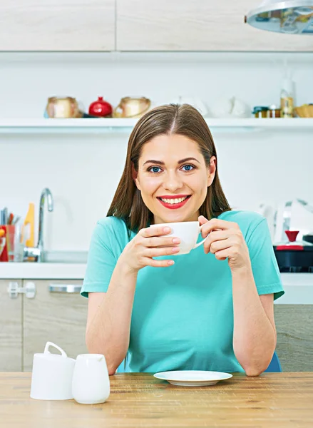 Kvinna sitter i köket med kaffekopp — Stockfoto