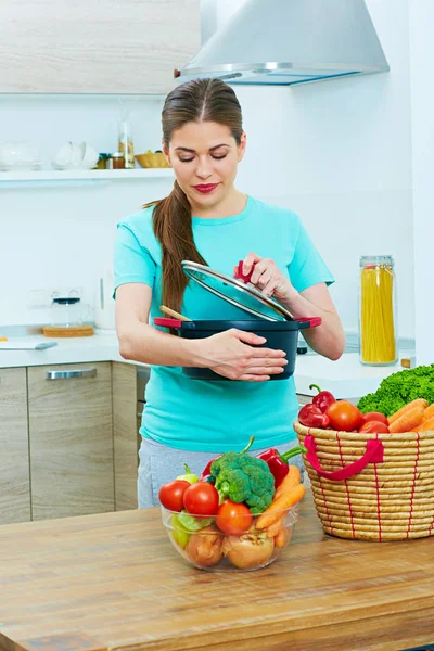 Kobieta w kuchni trzymając garnek — Zdjęcie stockowe