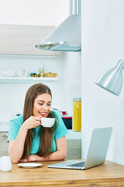 Mujer con portátil sentado en la cocina —  Fotos de Stock