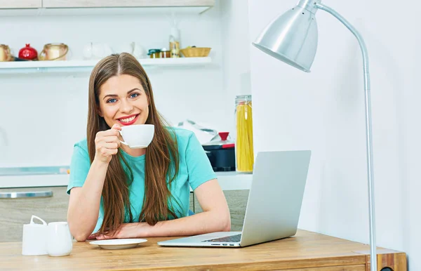 Kvinna med laptop sitter i köket — Stockfoto