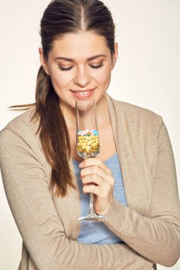 Vitamini kokteyl cam tutan gülümseyen genç kadın.