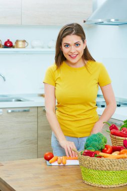 kadın mutfakta sebze yemek. gülümseyen genç kadın 