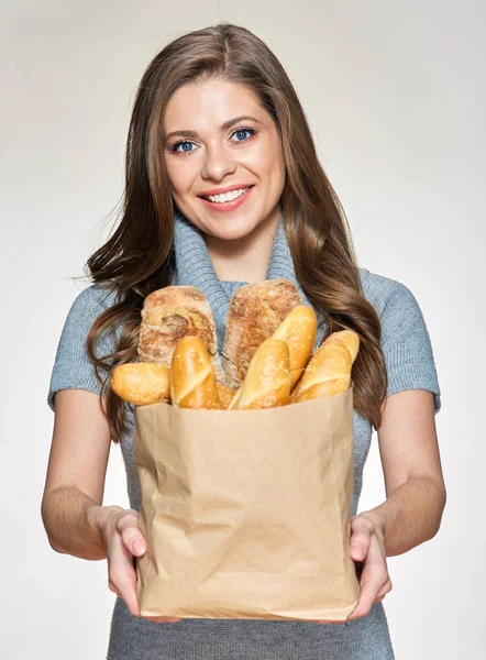 woman holding paper bag with bread