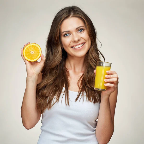 Sonriente mujer sosteniendo jugo de naranja vaso con media naranja fruta . — Foto de Stock