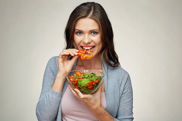Молодая женщина ест овощной салат. изолированный портрет . — стоковое фото