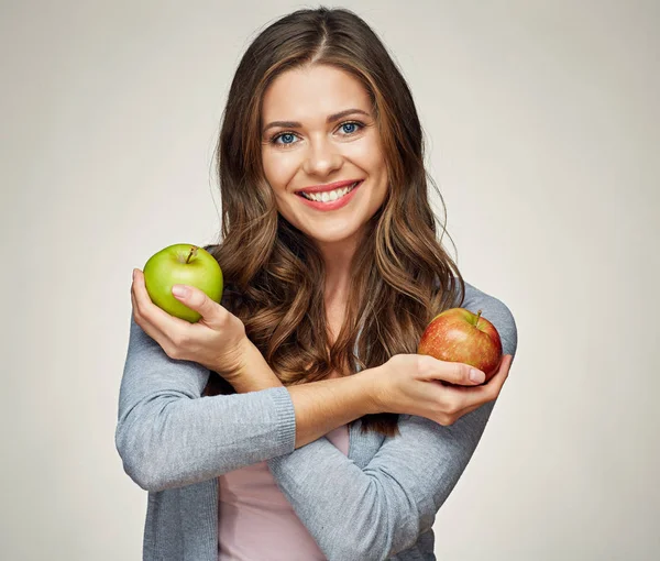 gülümseyen genç kadın iki elma, kırmızı ve yeşil holding. 