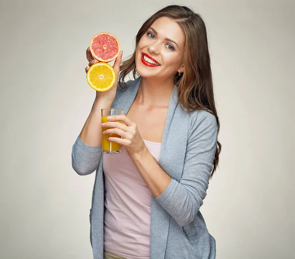 Sonriente mujer sosteniendo jugo vaso con media naranja y pomelo — Foto de Stock