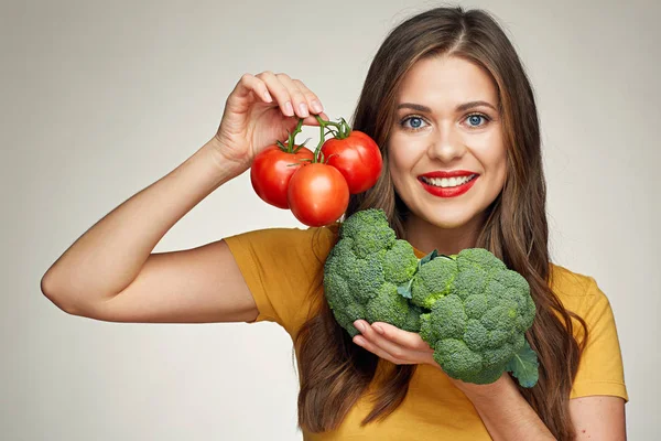 Lachende vrouw geïsoleerde portret met tomaten en broccoli. — Stockfoto