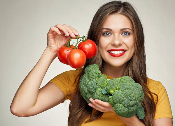 Lachende vrouw geïsoleerde portret met tomaten en broccoli. — Stockfoto