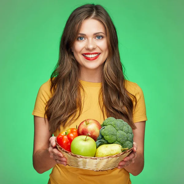 Joven mujer sonriente sosteniendo canasta de paja con frutas y vegetab —  Fotos de Stock