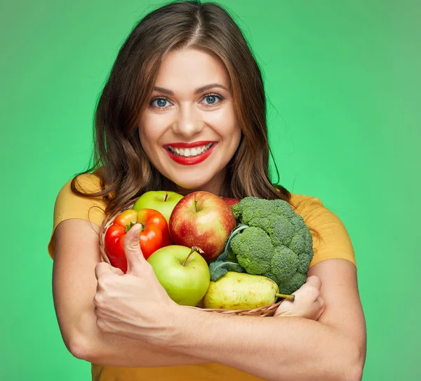 Joven mujer sonriente sosteniendo canasta de paja con frutas y vegetab —  Fotos de Stock