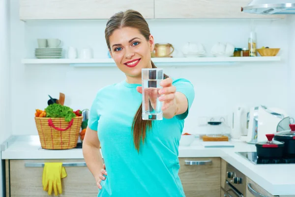 Ung kvinna anläggning vattenglas — Stockfoto