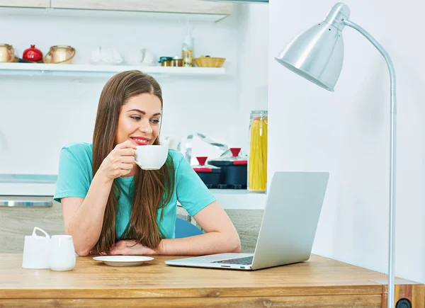 Kvinna med laptop sitter i köket — Stockfoto