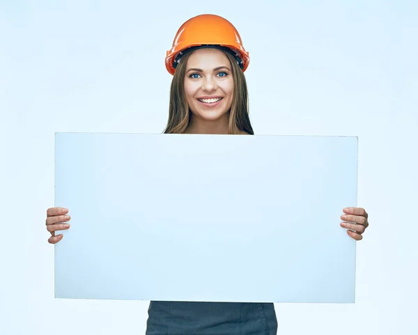 Улыбающаяся женщина в защитном шлеме строителя держит белый банн — стоковое фото