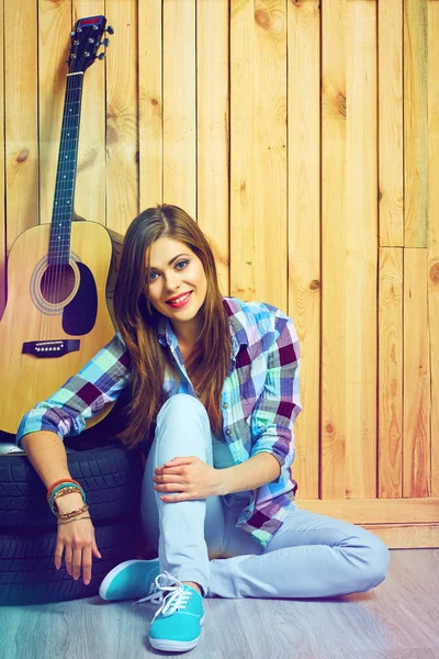 gitar ve lastikleri ile katta oturan kadın