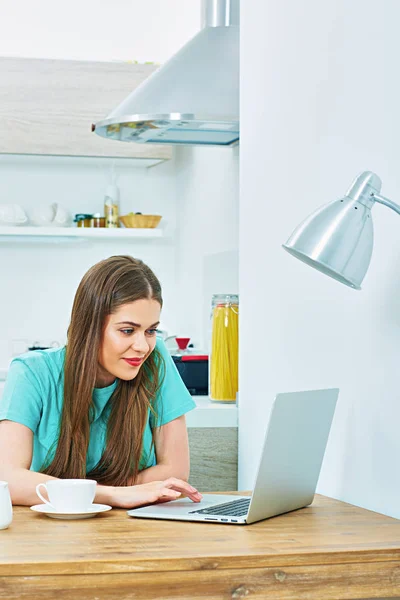 Kvinna med laptop sitter i köket — Stockfoto
