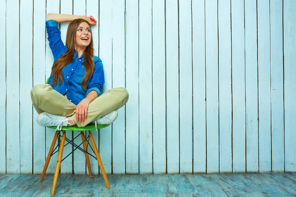 Mujer joven sentada en silla verde — Foto de Stock