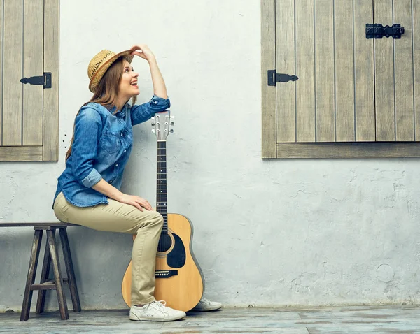 Жінка спирається на акустичну гітару — стокове фото