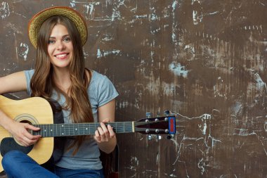 Akustik gitar ile gülümseyen genç kadın portre.