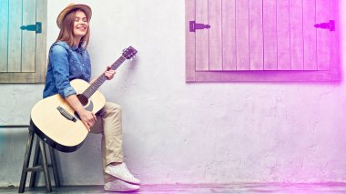 Sokak bankta oturan gitar ile gülümseyen kadın 